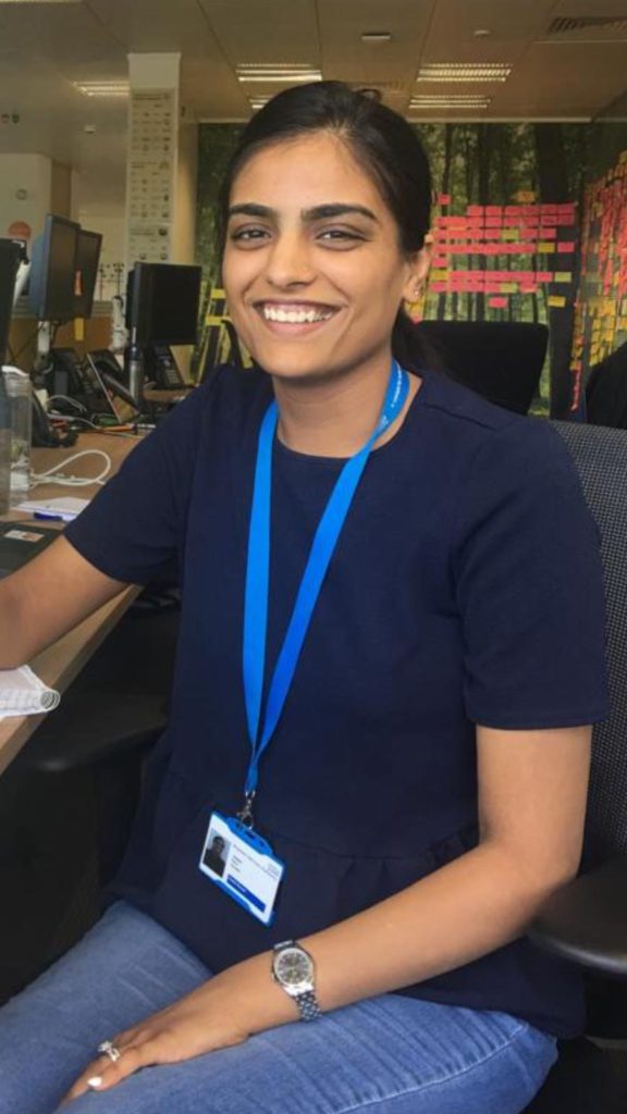 Avneet Jagpal sat in open plan office beside desk and computer monitors.